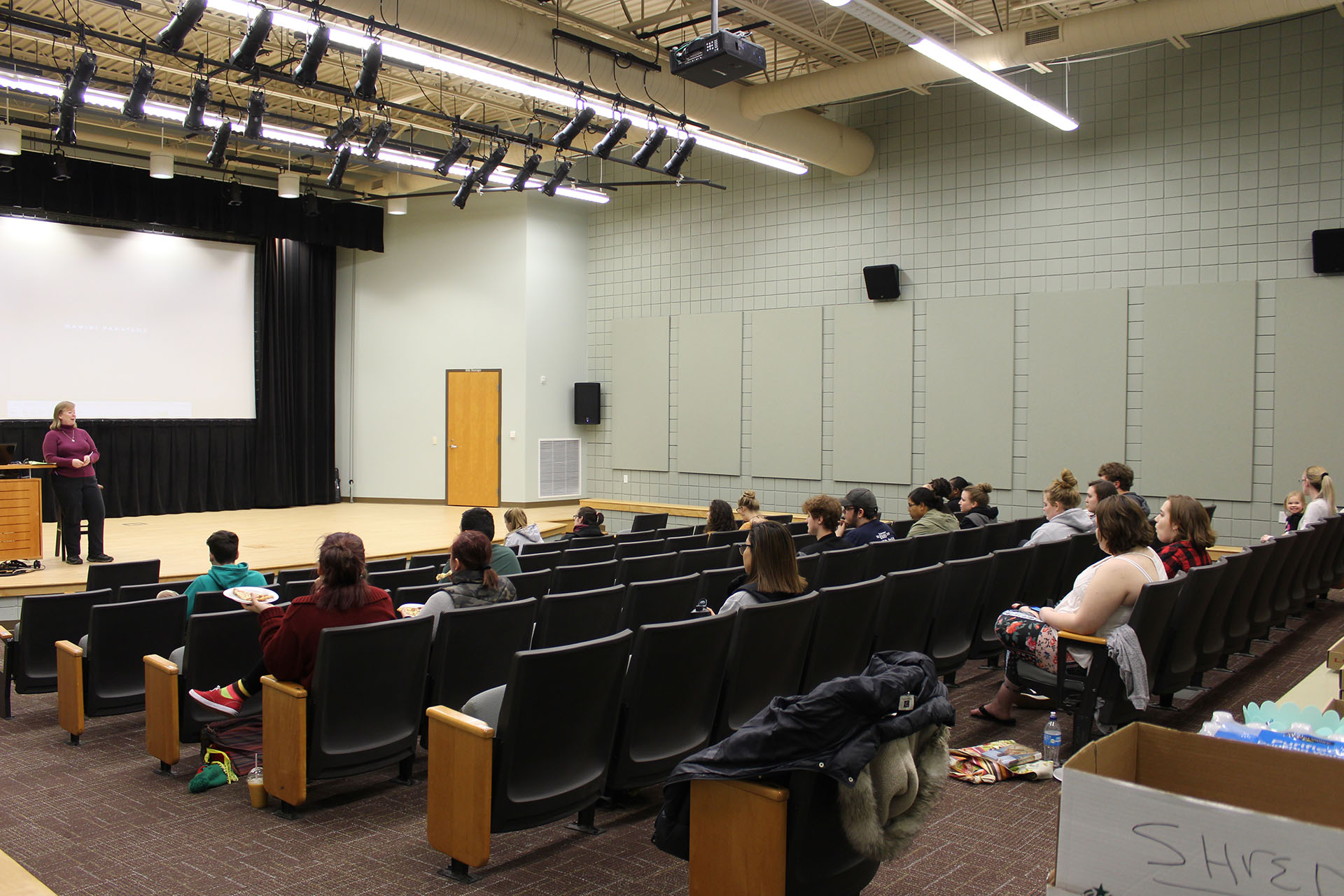 Students sitting in the Student Activity Center Events Theatre listening to a spreaker